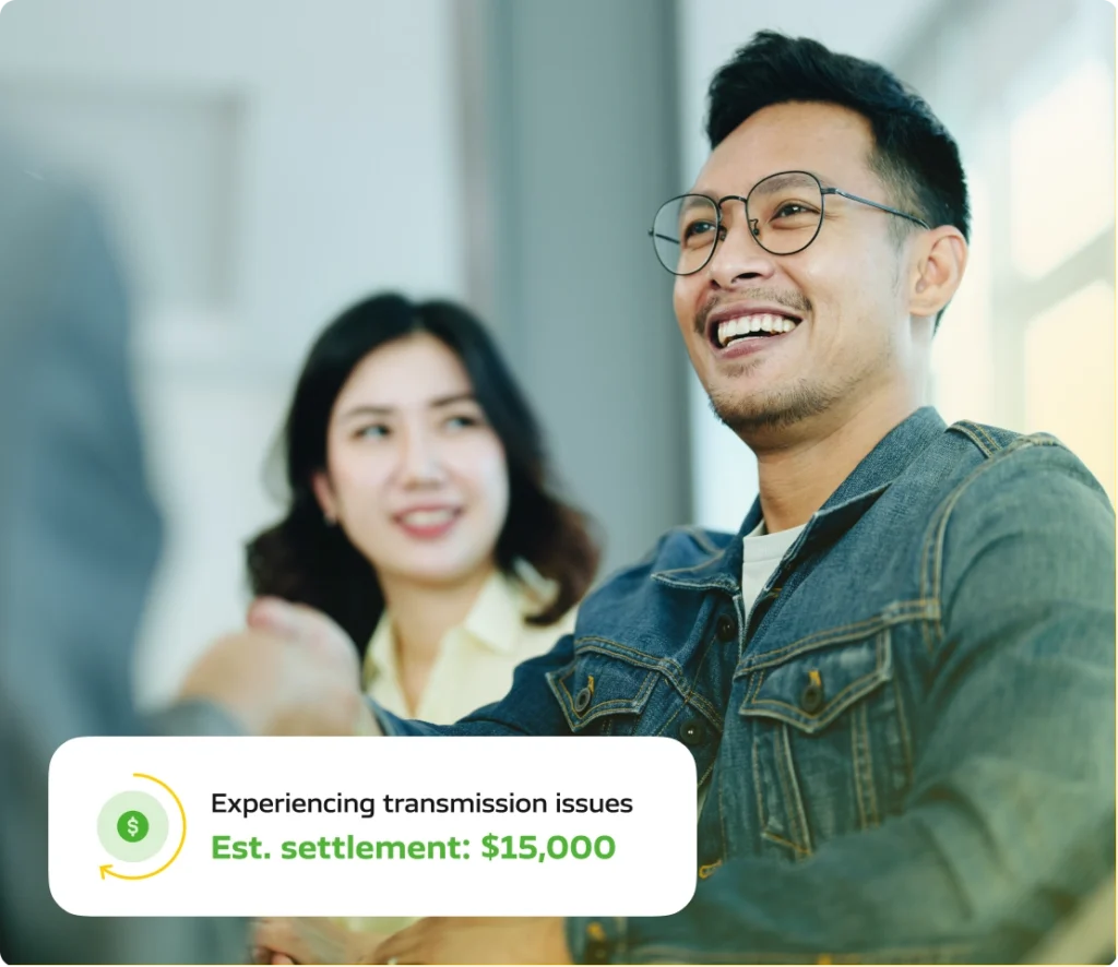 Young couple sitting and speaking happily with a Lemon Lawyers consultant.